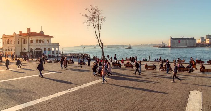 Istanbul, Turkey - March 03, 2020: People at Kadikoy Ferry terminal at sunset, with Ferry Ship going and arriving from Besiktas. 4k time lapse.