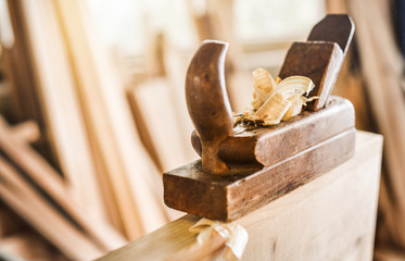 The carpenters using old spokeshave or plane to decorate the woodboard.