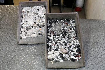 Zwei Metallschalen mit menschlicher Asche und Knochenfragmenten nach der Ein&auml;scherung in einem Krematorium