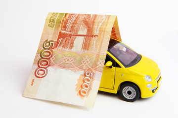 Car insurance concept. Russian  banknote over toy yellow car on white background.	