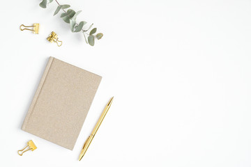 Flat lay home office desk. Female workspace with paper notepad and golden accessories on white background. Top view feminine workplace - obrazy, fototapety, plakaty