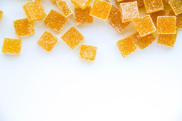 Pineapple, lemon, vanilla pate de fruit (jelly, marmalade, fruit candy) covered with sugar. White background, top view. There is a copy space for your text.