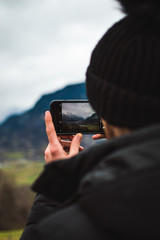 man taking picture on cell phone