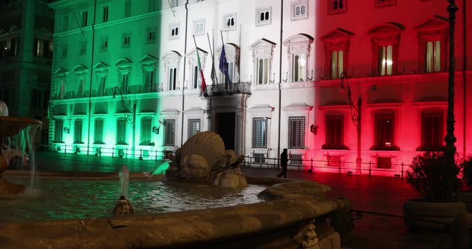 Rome, Italy - March 24, 2020: Palazzo Chigi, seat of the Italian government, facade of the building illuminated with the colors of the Italian flag. Coronavirus emergency Italy.