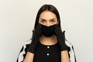 Coronavirus, a young girl in a black protective mask and black gloves, dressed in black clothes