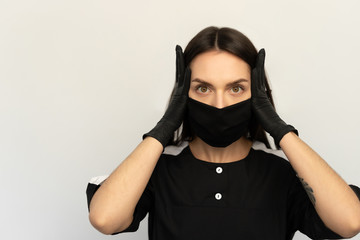 Coronavirus, a young girl in a black protective mask and black gloves, dressed in black clothes