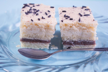 Homemade cake with vanilla and chocolate layers on blue background
