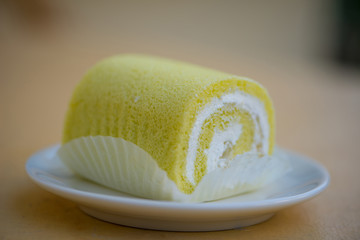 Sponge cake cream roll on white dish show bakery background