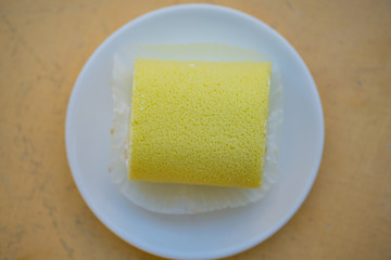 Sponge cake cream roll on white dish show bakery background
