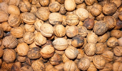 Background of walnuts peeled, a ray of sun falls on them.