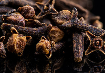 dried cloves spice stacking on a black background