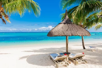 Papier Peint photo Le Morne, Maurice Chairs with umbrella at luxury beach with palms and blue ocean.