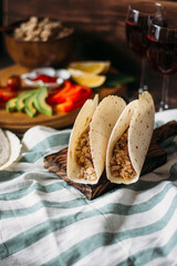 Taco on a wooden Board on a dark background. The view from the top. Mexican Taco cuisine. The view from the top. Mexican cuisine