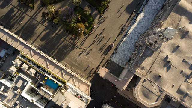 Top down aerial view of Arequipa's white city main square corner - UNESCO world heritage site - white sillar cathedral, geometric park, shadows of people walking