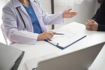 Female medicine doctor working on table with consulting patient