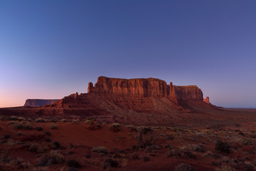 Obraz na płótnie Canvas The last rays of the setting sun illuminate iconic view of Monument Valley on the border between Arizona and Utah, USA