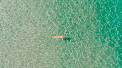 Girl enjoying a sunny and calm day in the sea. Top view. Best relaxation. Summer afternoon by the sea
