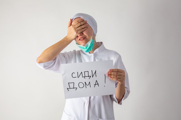 Girl doctor in mask holds a tablet in his hands - Stay home