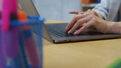 Beauty female hands typing busy on laptop keyboard on office desk. Close-up of young business woman working on portable computer in workspace.