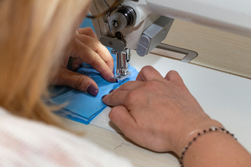 Mascherine antivirus cucite a mano da una sarta 