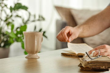 Desk of free space and blurred interior with window and man hands 