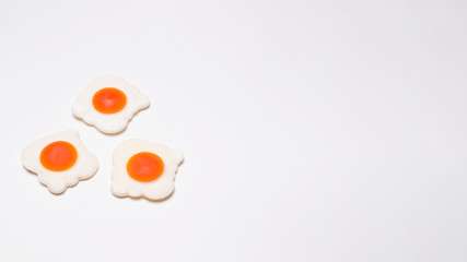 Widescreen photo of three jelly eggs in the lower right on a white background, close-up.