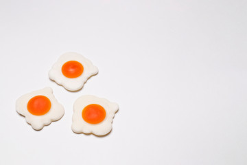 Three jelly fried eggs on the left on a white background, close-up. Sweet photo for your delicious design.