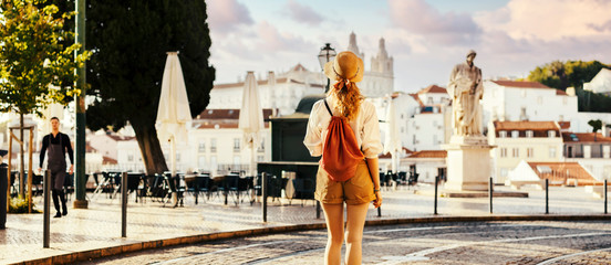 Young tourist traveling through beautiful sunny european city and looking at view, rear view