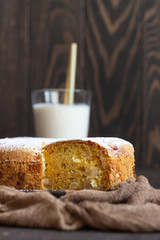 Homemade delicious sponge or soft cake on a dark brown concrete background. Freshly baked Sharlotka, sponge apple cake.
