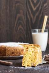 Homemade delicious sponge or soft cake on a dark brown concrete background. Freshly baked Sharlotka, sponge apple cake.