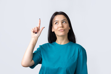 Happy young caucasian female  in a blue t-shirt pointing fingers away