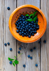 Blueberries  in a yellow bowl on the wooden table
