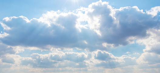 Sky with curly clouds in the rays of the sun_