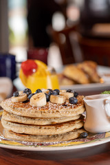 Tall stack pancakes with bananas and blueberries
