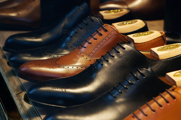Classic men's shoes made of genuine leather in shop window. Concept of diversity, high quality, elegance, honest business relationship
