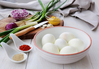 Making egg salad with hard-boiled eggs, spices and ingredients