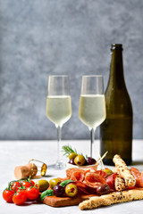 Traditional Italian appetizers antipasto : salami, bresaola, prosciutto parma, olives. Aperitif in Italy in Florence, Rome, aperitif in Milan. Two glasses of Prosecco and sticks of cereal bread