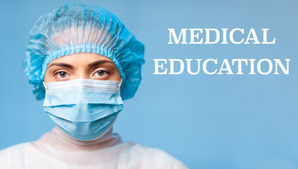 MEDICAL EDUCATION. Portrait of a young woman doctor in a protective mask, a medical cap on a blue background. Copy space. Space for logo