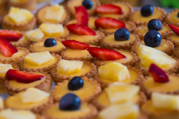 Fruit tartlets dessert with blueberry, pineapple and strawberry