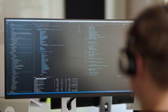 Real male web programmer coding javascript, php, symfony, react at work 