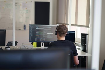 Real male web programmer coding javascript, php, symfony, react at work 