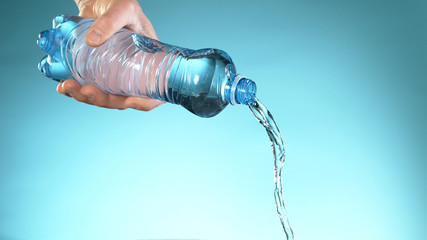 Naklejka na ściany i meble Freeze motion of pouring water from plastic bottle