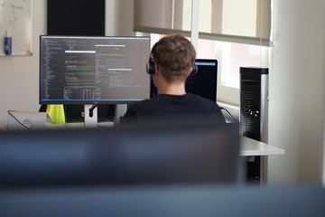 Real male web programmer coding javascript, php, symfony, react at work 