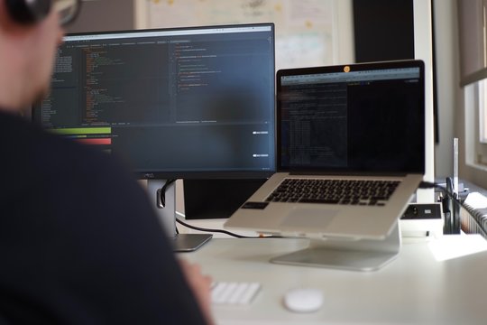 Real male web programmer coding javascript, php, symfony, react at work 