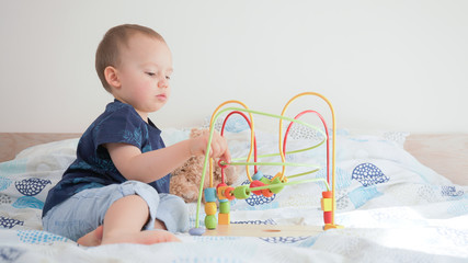 Cute small toddler doing brain exercises. Baby boy playing development montessori games. 