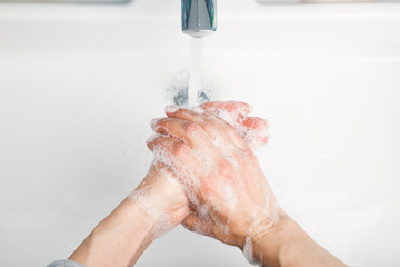 Fototapeta premium Person washing hands protective measures against coronavirus germ and bacteria spreading