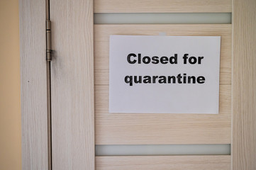 The inscription on the door is “closed for quarantined”. Coronavirus epidemic. Pandemic of the 21st century.