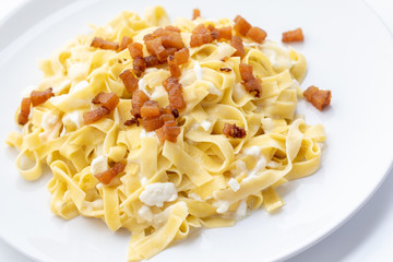 close up of fresh homemade pasta with cheese and fried bacon