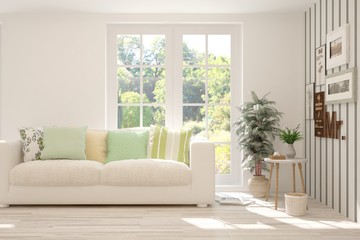 White living room with sofa and summer landscape in window. Scandinavian interior design. 3D illustration