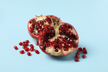 Pomegranate and seeds on blue background. Concept of juicy fruit